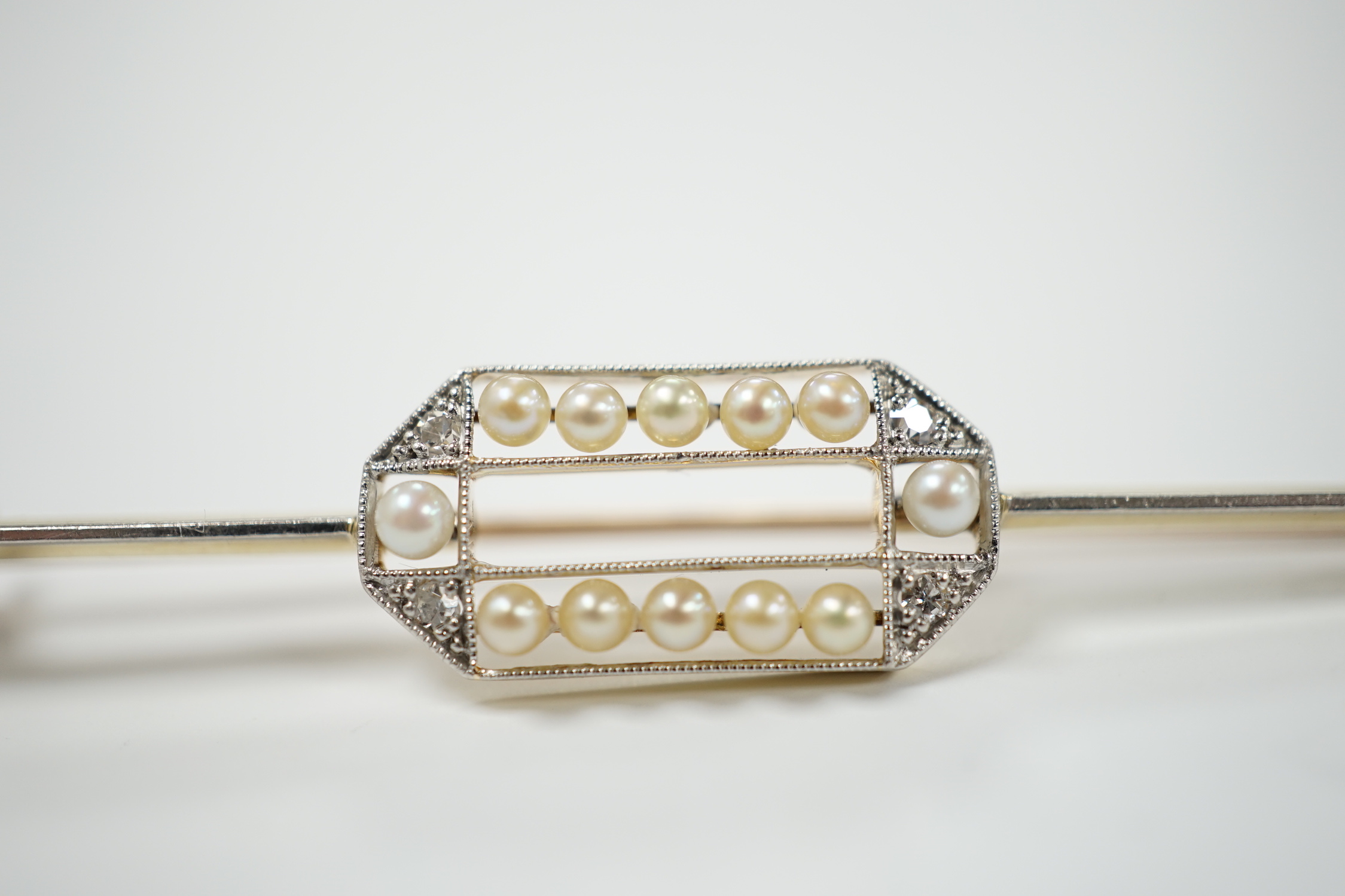 A Belle Epoque 15ct, diamond and seed pearl set bar brooch, 63mm, gross weight 3.9 grams.